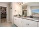 Bright bathroom with a double vanity, grey counters and an enclosed walk-in closet at 157 Donovan Ave, Locust Grove, GA 30248