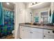 Bright bathroom with a blue shower curtain, and a gray countertop with cabinets at 157 Donovan Ave, Locust Grove, GA 30248