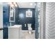 The cozy full bathroom has elegant, dark blue walls, a white vanity with basin sink, and tiled shower at 157 Donovan Ave, Locust Grove, GA 30248