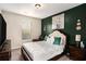 Cozy bedroom with a queen bed, dark accent wall, and a window with natural light at 157 Donovan Ave, Locust Grove, GA 30248