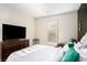 Comfortable bedroom with a plush bed, large window, and a dark accent wall for a calming atmosphere at 157 Donovan Ave, Locust Grove, GA 30248