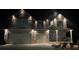 Beautiful two-story home with elegant exterior lighting illuminating the façade and yard at night at 157 Donovan Ave, Locust Grove, GA 30248
