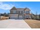 Charming two-story home with a three-car garage and lovely curb appeal on a sunny day at 157 Donovan Ave, Locust Grove, GA 30248