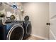 Modern laundry room with a front-load washer and dryer and shelf storage at 157 Donovan Ave, Locust Grove, GA 30248