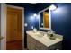 Chic powder room with navy walls, white vanity, and decorative jars on the countertop at 3548 Liberty Ln, Marietta, GA 30062