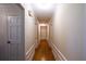 Long hallway with hardwood floors, white wainscoting, and multiple doorways at 3548 Liberty Ln, Marietta, GA 30062