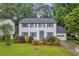 Charming two-story home featuring white siding, gray shutters, landscaped yard, and attached garage at 6338 Boyett Dr, Norcross, GA 30093
