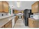 Charming kitchen featuring wood cabinets, laminate countertops, and black appliances at 6338 Boyett Dr, Norcross, GA 30093