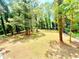 Large backyard featuring green grass and trees with ample space for outdoor activities and gardening at 6965 Kimberland Gardens Ln, Lithonia, GA 30058
