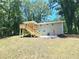 Newly constructed covered deck with stairs offers outdoor entertaining, complemented by a lush, private backyard at 6965 Kimberland Gardens Ln, Lithonia, GA 30058
