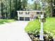 Charming split-level home with a two-car garage, freshly painted exterior, and well-manicured front lawn at 6965 Kimberland Gardens Ln, Lithonia, GA 30058