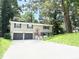 Charming split-level home with a two-car garage, freshly painted exterior, and well-manicured front lawn at 6965 Kimberland Gardens Ln, Lithonia, GA 30058