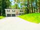 Charming two-story home with a well-manicured lawn, a two-car garage, and a freshly painted exterior at 6965 Kimberland Gardens Ln, Lithonia, GA 30058