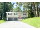 Front exterior view of home with a two-car garage, driveway, and landscaped front yard at 6965 Kimberland Gardens Ln, Lithonia, GA 30058