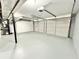 Spacious two car garage featuring gray floors and white doors for vehicles and extra storage space at 6965 Kimberland Gardens Ln, Lithonia, GA 30058