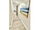 Well-lit hallway leading to a stylishly decorated living area, enhanced by an ocean themed painting at 6965 Kimberland Gardens Ln, Lithonia, GA 30058