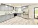 Modern kitchen featuring gray cabinets, stainless steel appliances, granite countertops, and laminate flooring at 6965 Kimberland Gardens Ln, Lithonia, GA 30058