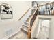Stylish staircase with iron balusters, wooden handrail, and gray laminate flooring leading to the upper level at 6965 Kimberland Gardens Ln, Lithonia, GA 30058