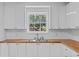Kitchenette showcasing new white cabinets, stylish butcher block countertop, and new window at 944 Herndon Nw St, Atlanta, GA 30318