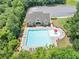 A stunning aerial view of a community pool next to a clubhouse, and a large parking lot, surrounded by lush trees at 1936 Lakeshore Overlook Circle Nw Cir, Kennesaw, GA 30152