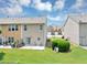 Exterior view of a townhome featuring a green lawn, small patio area, and privacy fence at 1936 Lakeshore Overlook Circle Nw Cir, Kennesaw, GA 30152