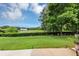 Backyard view with green grass, manicured hedges, and a tranquil view of the neighborhood lake at 1936 Lakeshore Overlook Circle Nw Cir, Kennesaw, GA 30152