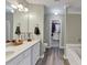 Bright bathroom with a double sink vanity, wood-look flooring, and a walk-in closet for ample storage space at 1936 Lakeshore Overlook Circle Nw Cir, Kennesaw, GA 30152