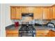 Gas range top with tile backsplash, light wood cabinets, and granite counters at 1936 Lakeshore Overlook Circle Nw Cir, Kennesaw, GA 30152