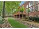 Manicured backyard showcases a brick home with outdoor deck, lush landscaping, and trees at 2145 Sugarstone Ct, Lawrenceville, GA 30043