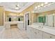Luxurious bathroom featuring tile floors, double sink vanity, large mirrors and gold fixtures at 2145 Sugarstone Ct, Lawrenceville, GA 30043