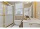 Bright bathroom featuring a shower with gold trim, toilet, vanity and a window with natural light at 2145 Sugarstone Ct, Lawrenceville, GA 30043