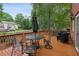 Outdoor deck with seating and table surrounded by trees offers a tranquil space to relax at 2145 Sugarstone Ct, Lawrenceville, GA 30043