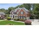 Traditional brick home featuring an attached garage and lush greenery at 2145 Sugarstone Ct, Lawrenceville, GA 30043