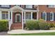 Close-up of the inviting front porch with brick steps and white columns at 2145 Sugarstone Ct, Lawrenceville, GA 30043