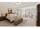Expansive main bedroom features tray ceilings, sitting area, lots of natural light, plush carpet and ottoman at 2145 Sugarstone Ct, Lawrenceville, GA 30043