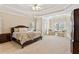 Expansive main bedroom features tray ceilings, sitting area, lots of natural light, and plush carpeting at 2145 Sugarstone Ct, Lawrenceville, GA 30043
