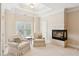 Bright sitting area adjacent to fireplace, featuring cozy armchairs, tray ceilings, and lots of natural light at 2145 Sugarstone Ct, Lawrenceville, GA 30043