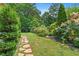Serene backyard with lush landscaping, rock path, and mature trees, creating a private outdoor oasis at 407 Westside Dr, Roswell, GA 30075