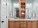 A double vanity features a marble countertop, mirrors, and a central shelving for a spa-like feel at 407 Westside Dr, Roswell, GA 30075