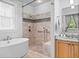 The luxurious bathroom features a soaking tub, a tiled shower, and a vanity with ample natural light at 407 Westside Dr, Roswell, GA 30075
