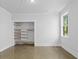 A well lit bedroom features a closet with wood shelving and a window, enhancing comfort and convenience at 407 Westside Dr, Roswell, GA 30075