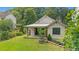 Home exterior featuring a well-manicured lawn, mature trees, and a covered patio at 407 Westside Dr, Roswell, GA 30075