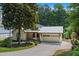 Charming home with a light siding, metal roof, attached garage, and well-manicured front yard landscaping at 407 Westside Dr, Roswell, GA 30075