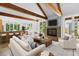 Open-concept living room boasts a cozy fireplace, exposed beams, and seamless access to the kitchen and outdoor views at 407 Westside Dr, Roswell, GA 30075