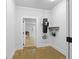 Functional mudroom featuring white walls, concrete floors, and storage racks with an open door at 407 Westside Dr, Roswell, GA 30075