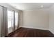 Spacious bedroom featuring hardwood floors, large windows with curtains, and ample natural light at 7790 Stratford Ln, Atlanta, GA 30350