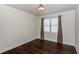 Cozy bedroom featuring hardwood floors, a window with curtains and base molding at 7790 Stratford Ln, Atlanta, GA 30350