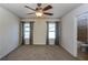 Bedroom with ceiling fan/light, neutral carpet, two windows, and an ensuite bathroom at 7790 Stratford Ln, Atlanta, GA 30350
