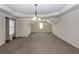 Large carpeted bonus room featuring a tray ceiling, ceiling fan, and two large windows at 7790 Stratford Ln, Atlanta, GA 30350
