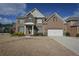 Traditional brick home with a two-car garage and a well-manicured lawn under a partly cloudy sky at 7790 Stratford Ln, Atlanta, GA 30350